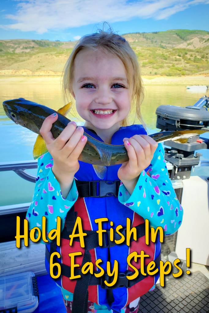 Hold A Fish: GSO Fishing Youth angler on their pontoon boat holding a brown trout at Blue Mesa Reservoir